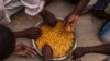 Migrants share a bowl of pasta during their lunch at the courtyard of a detention center for migrants, in the village of Karareem, around 50 kilometers from Misrata, Libya, Sept. 25, 2016. Libya is an important transit and destination country for migrants who arrive seeking employment or a path to Europe.