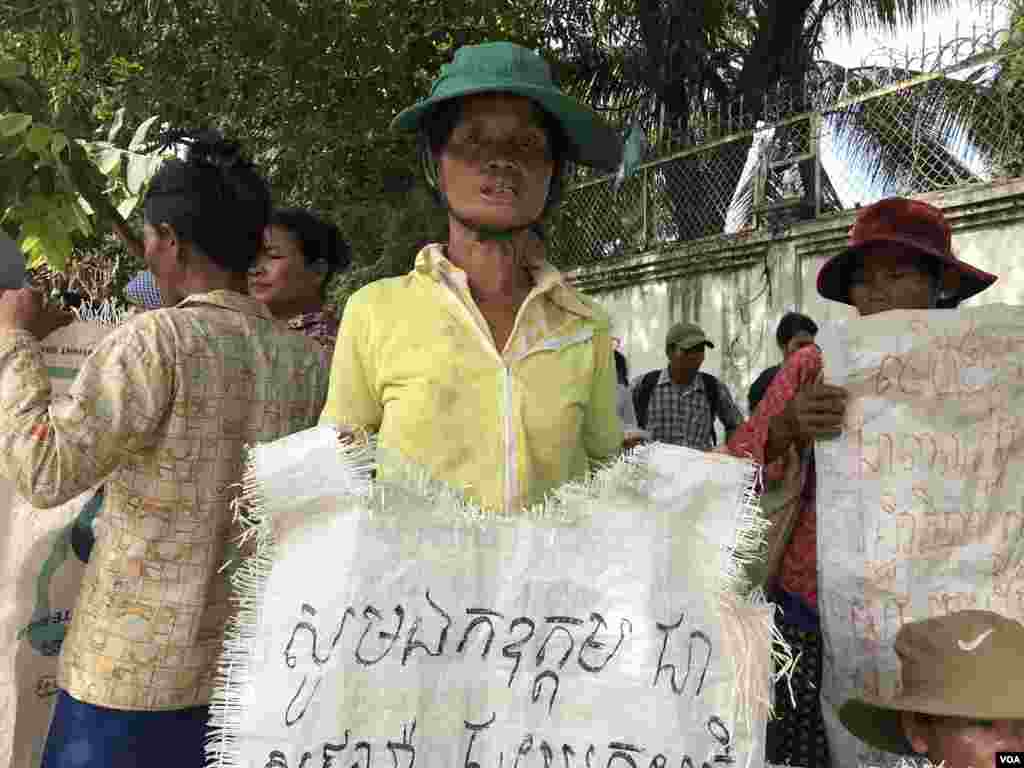 ស្ត្រីអ្នកតវ៉ាមួយរូបកាន់បដាអំពាវនាវឲ្យមានដំណោះស្រាយដីធ្លីនៅក្រសួងរៀបចំដែនដី ទីក្រុងភ្នំពេញ ថ្ងៃទី២២ ខែសីហា ឆ្នាំ២០១៩។ (ហ៊ុល រស្មី/VOA)