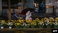 2023年1月21日，中國中部湖北省武漢市，一名沿街賣花的婦女在農曆新年前夕等待顧客。
