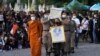 Police carry a coffin containing a victim in the day care center attack for cremation at Wat Rat Samakee temple in Uthai Sawan, northeastern Thailand, Tuesday, Oct. 11, 2022.