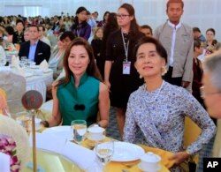 馬來西亞女演員楊紫瓊（Michelle Yeoh）與緬甸反對派領導人昂山素姬（Aung San Suu Kyi）2014年3月9日在仰光的一次會議上坐在一起。