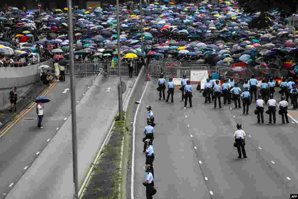 2019年6月12日香港抗議者在立法會外反對逃犯條例修訂,警察在道路上巡邏。數以萬計的抗議者封鎖了主要道路,致使香港中部地區癱瘓。隨著人群繼續擴大,立法會表示推遲逃犯條例修訂二讀。