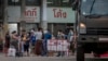 Migrant workers and their families are prepared to be taken to a field hospital for COVID-19 patents in Samut Sakhon, South of Bangkok, Thailand, Monday, Jan. 4, 2021. (AP Photo/Gemunu Amarasinghe)