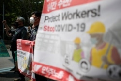 Members of the Korean Confederation of Trade Unions wearing face masks to help protect against the spread of the new coronavirus, shout slogans as they march during a May Day rally in Seoul, South Korea, May 1, 2020.