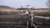 FILE - In this handout photo taken from video released by Russian Defense Ministry Press Service on March 25, 2024, a Russian soldier carries a captured Ukrainian drone restored and modernized by the military at an undisclosed location in Ukraine.