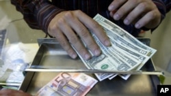 Échange d'euros et de dollars américains dans un kiosque, dans le centre-ville de Milan, en Italie, photo d'archive du 5 juillet 2005. 