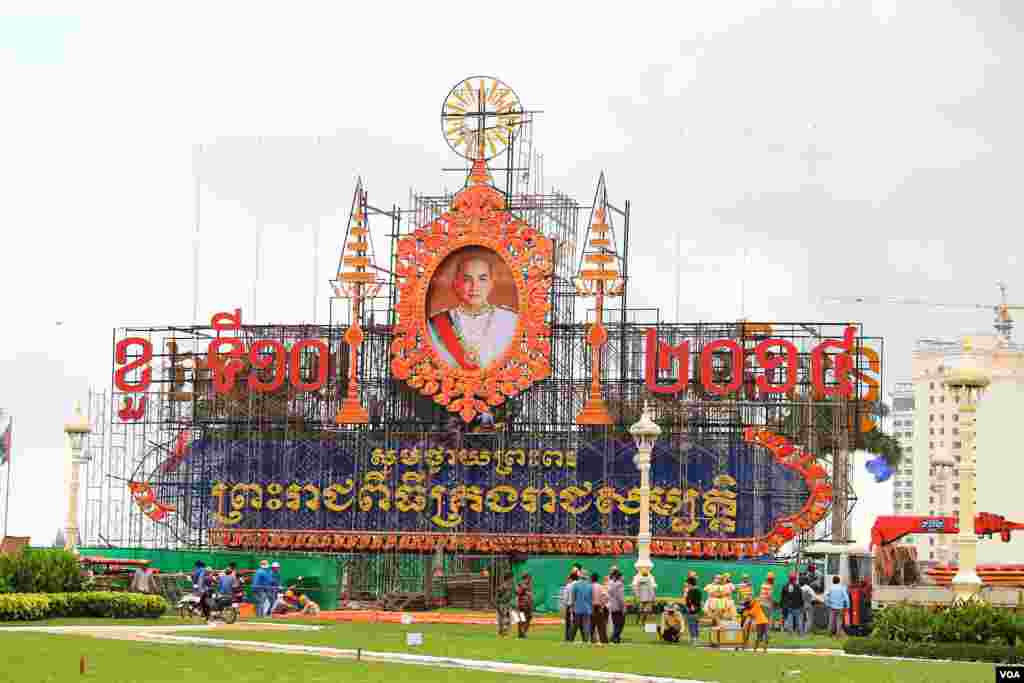 ការរៀបចំតុបតែងលម្អនៅមុខព្រះបរមរាជវាំងក្នុងរាជធានីភ្នំពេញ ដើម្បីអបអរថ្វាយព្រះពរខួបទី១០នៃព្រះរាជពិធីគ្រងរាជសម្បត្តិរបស់ព្រះបាទសម្ដេចព្រះបរមនាថ នរោត្តម សីហមុនី នៅថ្ងៃទី ២៥ ខែតុលា ឆ្នាំ២០១៤។ (នូវ ពៅលក្ខិណាVOA)