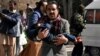 A man carries a boy as he walks away from the Bethel Memorial Methodist Church in Quetta, Pakistan, after gunmen attacked, Dec. 17, 2017.
