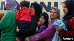 People queue to receive free food at a makeshift camp for migrants and refugees at the Greek-Macedonian border near the village of Idomeni, Greece, April 6, 2016. The U.N. refugee agency reports 65 million people were forcibly displaced last year.