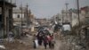 A Palestinian man rides a donkey-drawn cart transporting an old car to a scrap yard, in Gaza City.