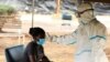 Vérification des températures lors du confinement national pour aider à freiner la propagation du coronavirus, dans un centre de dépistage à Harare, Zimbabwe, le 30 avril 2020.