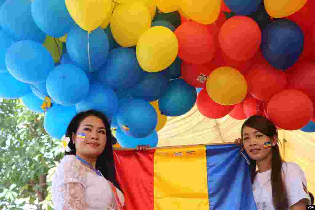 ស្រ្តីពីររូបឈរកាន់ប៉ោងប៉ោងដើម្បីរង់ចាំគណអធិបតីក្នុងពិធីមួយនៅវត្តចាស់នៃរាជធានីភ្នំពេញ នៅថ្ងៃទី០៤មិថុនា ឆ្នាំ២០១៦ នៅក្នុងការប្រារព្ធខួប៦៧ឆ្នាំ ថ្ងៃអាណានិគមបារាំងកាត់ផ្ទេរទឹកដីខ្មែរដែលបប្ចុប្បន្នហៅថាកម្ពុជាក្រោម ឲ្យប្រទេសវៀតណាមនៅឆ្នាំ១៩៤៩។(ឡេងឡែន/VOA) 