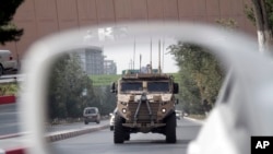 A patrolling U.S. armored vehicle is reflected in the mirror of a car in Kabul, Afghanistan, Aug. 23, 2017. 