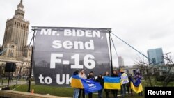 "Пане Байдене, надішліть в Україну F-16", - звернення до президента США виставили українці під час візиту Байдена до Польщі. Фото: Reuters/Aleksandra Szmigiel 