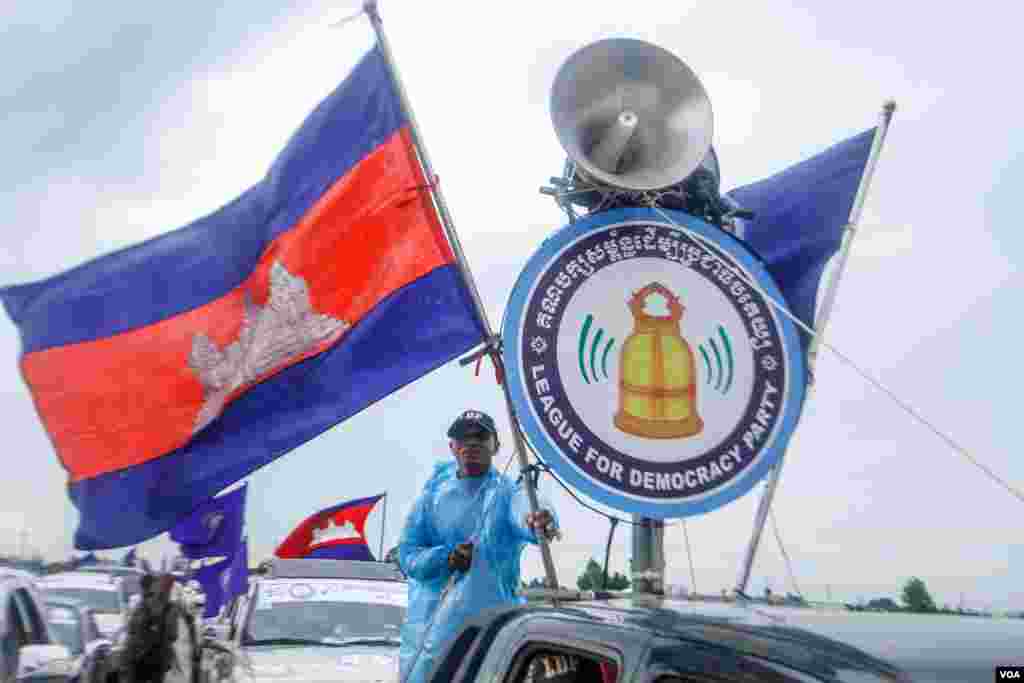 អ្នកគាំទ្រម្នាក់នៃគណបក្សសម្ព័ន្ធដើម្បីប្រជាធិបតេយ្យ កាន់ទង់ជាតិព្រះរាជាណាចក្រកម្ពុជា នៅក្នុងក្បួនឃោសនានយោបាយ នាថ្ងៃដំបូងនៃយុទ្ធនាការបោះឆ្នោត នៅលើមហាវិថីតេជោហ៊ុនសែន ហៅផ្លូវ៦០ម៉ែត្រ រាជធានីភ្នំពេញ កាលពីព្រឹកថ្ងៃទី០៧កក្កដា២០១៨។។ (គី ម៉េងលី/VOA) 