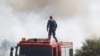 A firefighter looks at smoke from the roof of a fire vehicle after a wildfire broke out in Kitsi, a southern suburb of Athens on June 19, 2024.
