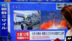 一名女士走過日本東京的一個正播放北韓試射導彈的新聞電視(2017年8月29日)