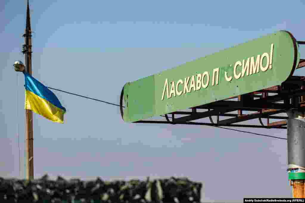 Їдемо з Катеринівки назад так само – через КПВВ «Золоте». Дорогою проїжджаємо розбиту заправку з простріленим кулями написом «Ласкаво просимо!» і прапором України.