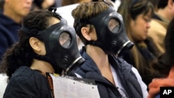 Des manifestants portent des masques à gaz pour protester contre une fuite de gaz à l'installation de stockage Aliso Canyon en Californie.