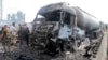 In this photo released by the Syrian official news agency SANA, Syrian security forces, emergency services and residents look at the remains of burned vehicles at the site of a bombing in Tartus, Syria, Sept. 5, 2016.