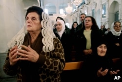 FILE - Syrian Christians and Muslims offer prayers for nuns held by rebels, at the Greek Orthodox Mariamiya Church in Damascus, Syria, Dec. 8, 2013.