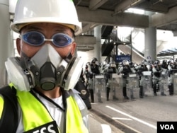 美國之音記者在香港機場報導香港反中民眾機場示威防暴警察清場的實況。（美國之音記者黎堡拍攝）