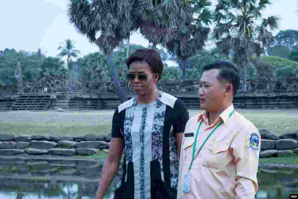 មគ្គុទ្ទេសក៍ទេសចរណ៍បង្ហាញដល់លោកស្រី Michelle Obama ក្នុងពេលដើរទស្សនានៅបរិវេណប្រាសាទអង្គរវត្ត នៅរសៀលថ្ងៃសៅរ៍ ទី២១ ខែមីនា ឆ្នាំ២០១៥។