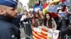 Demonstrators wave banners and flags as sacked Catalan leader Carles Puigdemont leaves a news conference at the Press Club Brussels Europe in Brussels, Belgium, Oct. 31, 2017. 