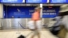File - Passengers walk past a South African Airways (SAA) customer desk at the O.R. Tambo International Airport in Johannesburg, South Africa, Jan. 21, 2020. 