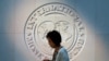 Une femme passe devant le logo du FMI à son siège à Washington, aux États-Unis, le 10 mai 2018. (REUTERS/Yuri Gripas) 