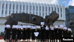 香港中文大學畢業生舉起被中國拘押的12名港人的姓名牌子。 （2020年11月19日）