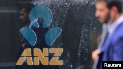 In this file photo, a pedestrian is reflected in the window of a branch of the Australia and New Zealand Banking Group (ANZ) in central Sydney, Australia, October 25, 2017. 