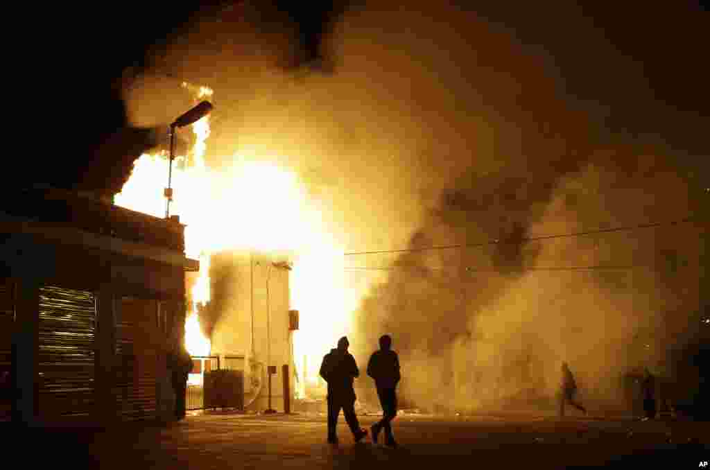 Des personnes marchent près d'un entrepôt en feu après l'annonce de la décision du grand jury, Ferguson, Missouri, le 24 novembre 2014.