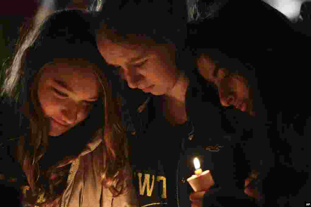 Kate Suba, à gauche, Jaden Albrecht, au milieu, and Simran Chand se recueillent devant un mémorial aux victimes du massacre de Sandy Hook