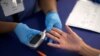 FILE - A person receives a test for diabetes at a free medical clinic in Los Angeles, California, Sept. 11, 2014. 
