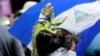 Una manifestante antigubernamental porta una iguana en la cabeza mientras participa en una protesta contra el gobierno del presidente nicaragüense, Daniel Ortega, en Managua, Nicaragua, el 15 de septiembre de 2018.