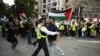 Petugas kepolisian menahan seorang aktivis pro-Palestina yang mencoba mendekat ke arah demonstran pro-Israel dalam aksi unjuk rasa untuk Palestina di London, pada 5 Oktober 2024. (Foto: AFP/Justin Tallis)