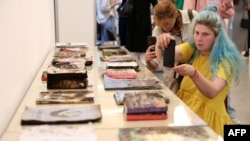 Пошкоджені книжки харківської типографії "Фактор-Друк", яка була зруйнована внаслідок російських обстрілів 23 травня 2024 року. Книги виставили для відвідувачів форуму "Книжковий Арсенал" у Києві. Фото: Anatolii Stepanov/AFP