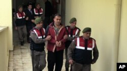 Des policiers turcs escortent des passeurs syriens Muwafaka Alabash (devant) et Asem Alfrhad (derrière) pour leur procès à Bodrum, Turquie, le vendredi 4 Mars 2016. (AP Photo)