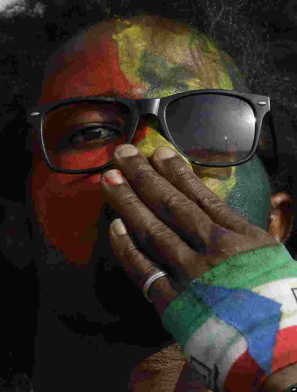 Un fan de l'équipe du Ghana avec son visage peint aux couleurs nationales du pays au cours du match de football de la Coupe d'Afrique des Nations Groupe C entre le Ghana et le Sénégal à Mongomo, la Guinée équatoriale, lundi 19 janvier 2015.