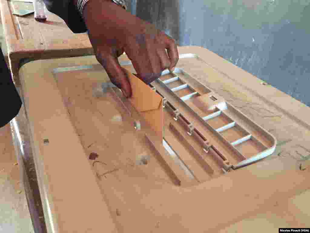 Dans le bureau de vote n°23 à l'école de Kirkissoye, à Niamey, les électeurs mettent leur bulletin dans l'urne, 21 février 2016 (VOA/Nicolas Pinault)