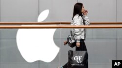 2019年2月26日一名女子從北京首都蘋果商店攜購物袋路過。