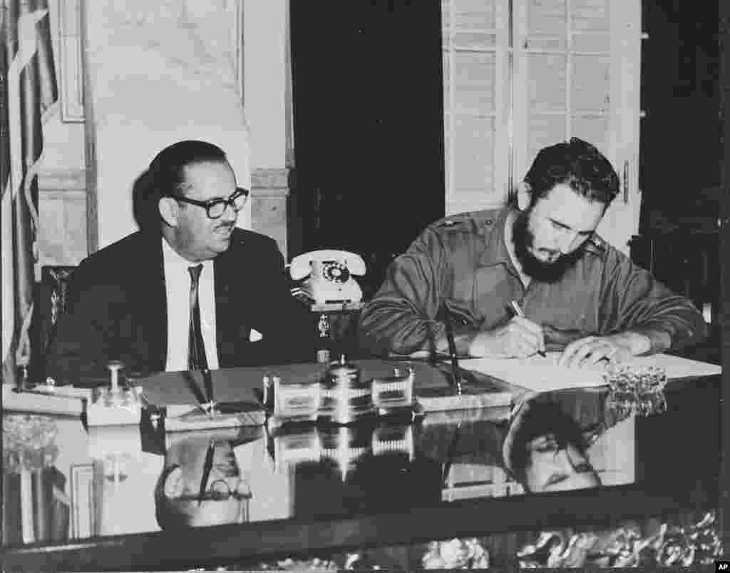 Fidel Castro, alors Premier ministre, signe un décret nationalisant toutes les banques américaines à Cuba, le 17 septembre 1960. 