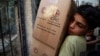 A boy unloads aid parcels in the rebel-held besieged town of Zamalka, in the Damascus suburbs, Syria, June 29, 2016. 
