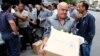 FILE - Displaced Syrians collect rations provided by the World Food Program in front of a distribution center in Damascus, Oct. 19, 2014.