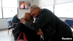 La sobreviviente de COVID-19 Santiaga Cerrato, de 85 años, que padece de Alzheimer, se despide de su compañera residente Antonia Sánchez, en el asilo de ancianos Centro Casaverde en Navalcarnero, en las afueras de Madrid, España, el 23 de diciembre 2020.