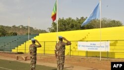 Des Casques bleus de la MINUSMA devant les drapeaux du Mali et de l'Onu, le 29 mai May 2015, au stade Mamadou Konaté N’tomikorobougou à Bamako, Mali. HABIBOU KOUYATE / AFP / HABIBOU KOUYATE
