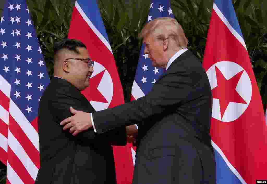 Shugaban Amurka Donald Trump da shugaban Koriya Ta Arewa Kim Jong Un suna shan hannu bayan sa hannu a yarjejeniya a taron kolin da suka gudanar a otel din Capella Hotel dake tsibirin Sentosa, Singapore, Juni 12, 2018.