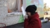 FILE - A woman cries outside a local kindergarten, which was damaged by explosions at a military depot in Svatove, Luhansk region, Ukraine, Oct. 30, 2015.