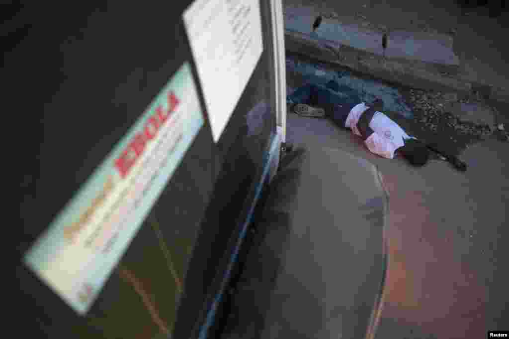 Le corps d'une victime soupçonnée d’Ebola retrouvé dans une rue de la ville de Koidu, dans le district de Kono orientale de la Sierra Leone, 18 décembre, 2014. REUTERS / Baz Ratner